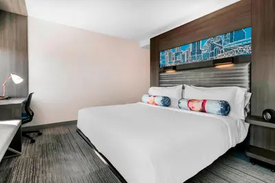 a hotel room with a large bed and a desk at Aloft Newport on the Levee in Newport