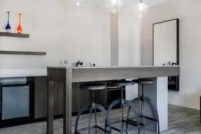 a bathroom with a counter with two stools and a mirror at Aloft Newport on the Levee in Newport