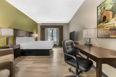 a hotel room with a bed and a desk and a computer at Best Western Plus Franciscan Square Inn & Suites Steubenville in Steubenville