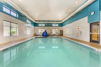 an indoor swimming pool with blue water in a building at Best Western Plus Franciscan Square Inn & Suites Steubenville in Steubenville