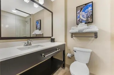 a bathroom with a sink and a toilet and a mirror at Best Western Plus Franciscan Square Inn & Suites Steubenville in Steubenville