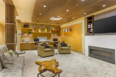 a lobby with a living room with a fireplace at Best Western Plus Franciscan Square Inn & Suites Steubenville in Steubenville