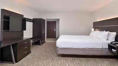 a hotel room with a bed and a flat screen tv at Holiday Inn Express & Suites - Parkersburg East by IHG in Parish-Morris Subdivision
