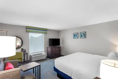 a bedroom with a bed and a couch and a television at Hampton Inn University Area, Huntington, Wv in Huntington