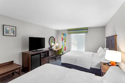 a hotel room with two beds and a television at Hampton Inn University Area, Huntington, Wv in Huntington