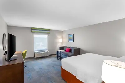 a hotel room with a bed and a couch at Hampton Inn University Area, Huntington, Wv in Huntington