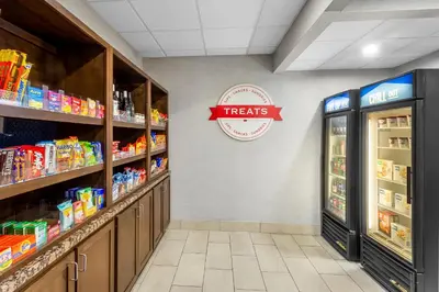 a grocery store aisle with a treats sign on the wall at Hampton Inn University Area, Huntington, Wv in Huntington