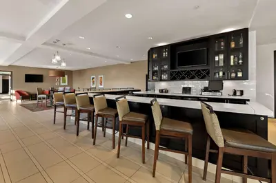 a bar in a hotel room with a bunch of chairs at Hilton Garden Inn Findlay in Findlay