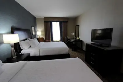 a hotel room with two beds and a flat screen tv at Hilton Garden Inn Findlay in Findlay