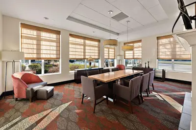 a dining room with a table and chairs and windows at Hilton Garden Inn Findlay in Findlay