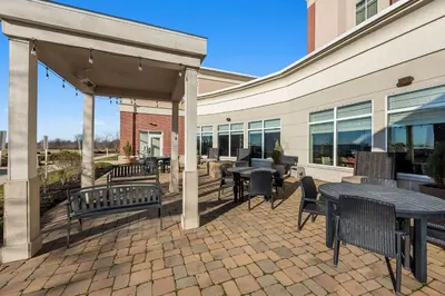 a patio with tables and chairs and a building at Hilton Garden Inn Findlay in Findlay