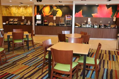 a restaurant with tables and chairs and a counter at Fairfield Inn & Suites by Marriott Bowling Green in Bowling Green