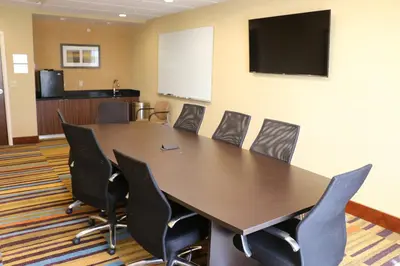 a conference room with a large wooden table and chairs at Fairfield Inn & Suites by Marriott Bowling Green in Bowling Green
