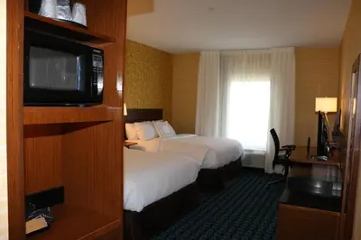 a hotel room with two beds and a flat screen tv at Fairfield Inn & Suites by Marriott Bowling Green in Bowling Green