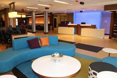 a living room with a blue couch and a table at Fairfield Inn & Suites by Marriott Bowling Green in Bowling Green