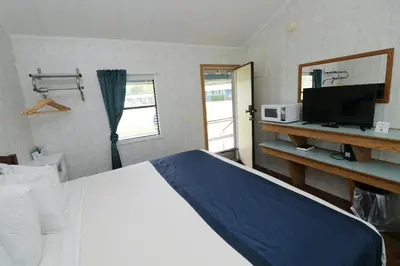 a hotel room with a bed and a tv and a mirror at Bird's Nest Resort in Put-in-Bay