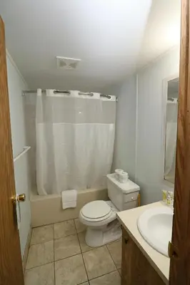 a white bathroom with a toilet and a sink at Bird's Nest Resort in Put-in-Bay