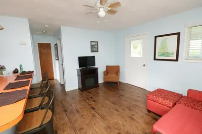 a living room with a red couch and a table at Bird's Nest Resort in Put-in-Bay