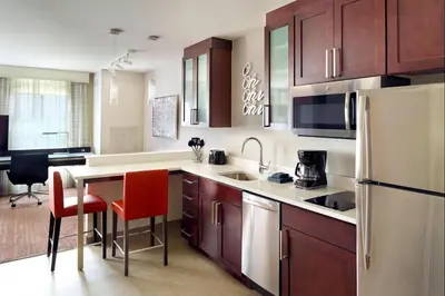 a kitchen with brown cabinets and a white refrigerator at Residence Inn by Marriott Columbus OSU in Columbus