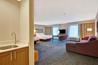 a hotel room with a king bed and a bathroom at Hampton Inn Suites Ashland, Ohio in Ashland