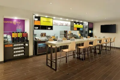 a restaurant with a bar with chairs and a counter at Home2 Suites By Hilton Middleburg Heights Cleveland in Middleburg Heights
