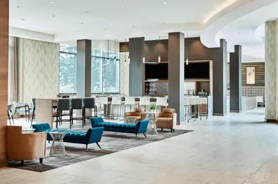 an open lobby with a bar and a kitchen at AC Hotel by Marriott Cincinnati at The Banks in Cincinnati