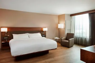 a hotel room with a bed and a chair at AC Hotel by Marriott Cincinnati at The Banks in Cincinnati