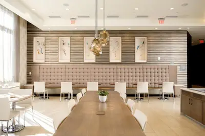 a dining room with a long table and white chairs at AC Hotel by Marriott Cincinnati at The Banks in Cincinnati