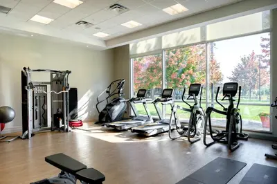 a gym with a bunch of treadmills and ellipticals at AC Hotel by Marriott Cincinnati at The Banks in Cincinnati