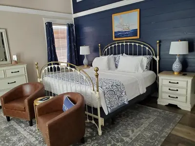 a bedroom with a bed and a chair at Anchor Inn Boutique Hotel in Put-in-Bay