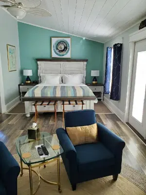 a bedroom with a bed and a couch and a glass table at Anchor Inn Boutique Hotel in Put-in-Bay