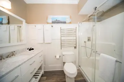 a white bathroom with a toilet and a shower at Anchor Inn Boutique Hotel in Put-in-Bay