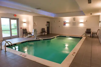 a large swimming pool with green water in a building at Fairfield Inn & Suites by Marriott Anderson in Anderson