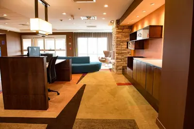 an office with a desk and a blue couch in a room at Fairfield Inn & Suites by Marriott Anderson in Anderson
