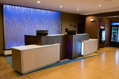 a lobby with a reception desk with a blue wall at Fairfield Inn & Suites by Marriott Anderson in Anderson