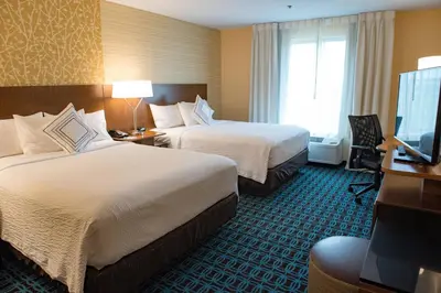 a hotel room with two beds and a flat screen tv at Fairfield Inn & Suites by Marriott Anderson in Anderson