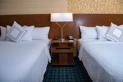 a hotel room with two beds and a lamp on a table at Fairfield Inn & Suites by Marriott Anderson in Anderson