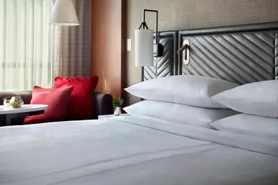 a bedroom with a bed with pillows and a chair at Marriott Columbus OSU in Columbus