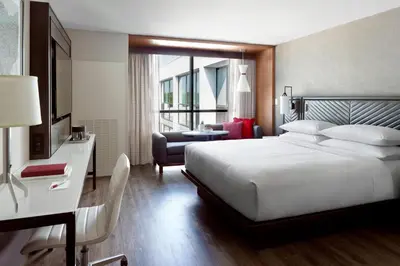 a bedroom with a large bed and a living room at Marriott Columbus OSU in Columbus