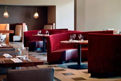 a restaurant with red booths and tables with wine glasses at Marriott Columbus OSU in Columbus