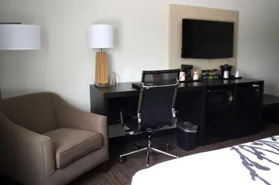 a hotel room with a desk and a chair and a television at Sleep Inn & Suites Galion in Galion