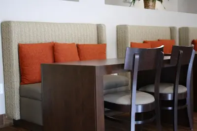 a dining room table with two chairs and an orange pillow at Sleep Inn & Suites Galion in Galion