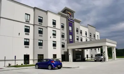 a blue car parked in front of a hotel at Sleep Inn & Suites Galion in Galion