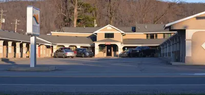 a row of buildings with cars parked in a parking lot at Travelers Inn in New Martinsville