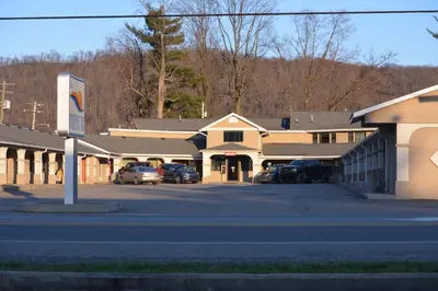 a building with cars parked in a parking lot at Travelers Inn in New Martinsville