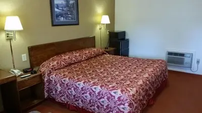 a hotel room with a bed and a telephone at Travelers Inn in New Martinsville