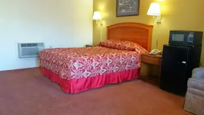 a hotel room with a bed and a television at Travelers Inn in New Martinsville