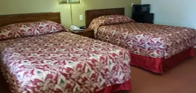 a hotel room with two beds in a room at Travelers Inn in New Martinsville