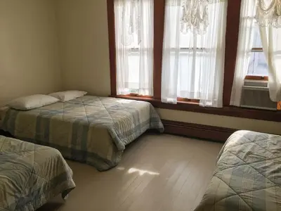 a bedroom with two beds and two windows at Aunt Jane's Two in Put-in-Bay