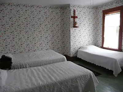 a bedroom with two beds and a cross on the wall at Aunt Jane's Two in Put-in-Bay